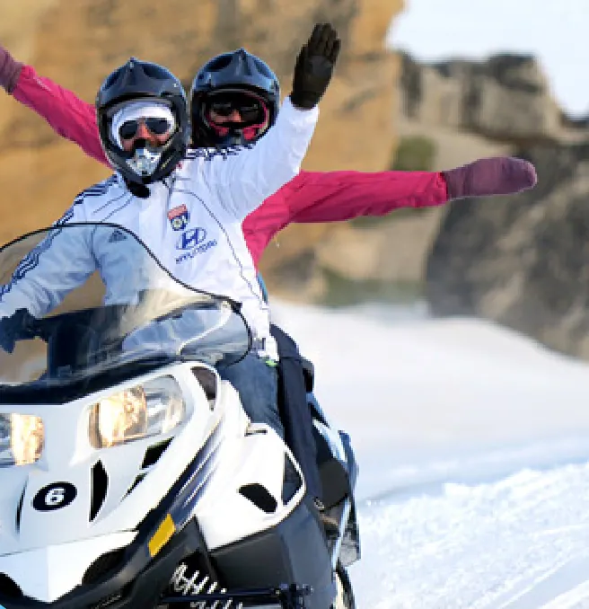 Aventura en moto de nieve entre las formaciones rocosas en invierno