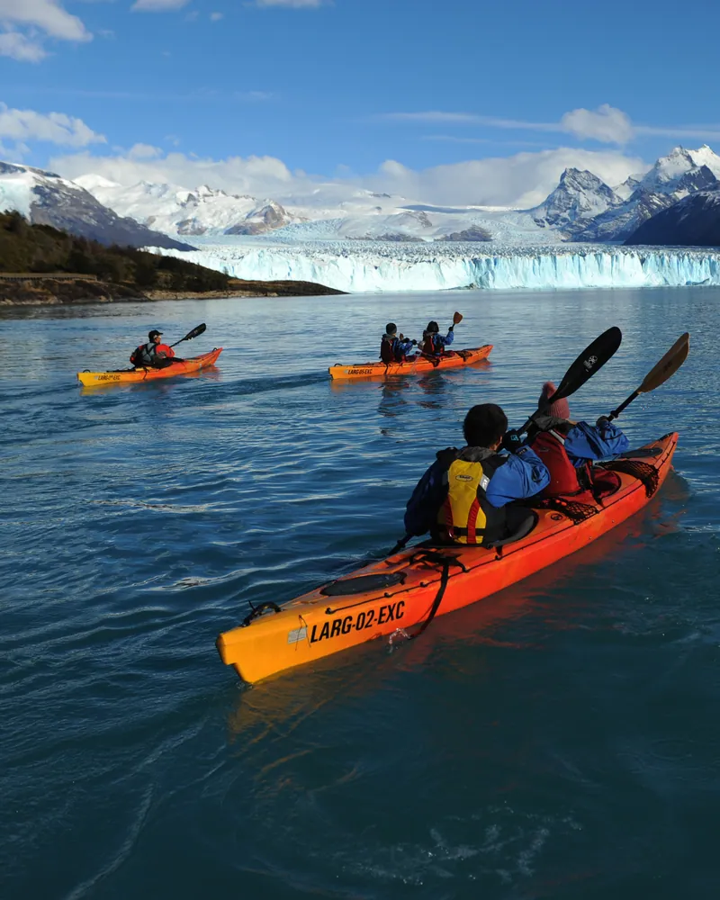 Kayaks navegando frente al Glaciar Perito Moreno y las montañas patagónicas