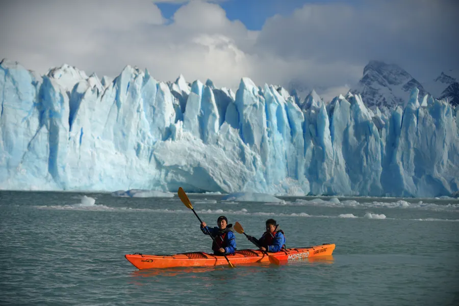 Dos personas remando frente a las paredes de hielo del Perito Moreno