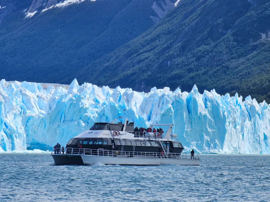 Embarcación navegando frente a las torres de hielo del Perito Moreno