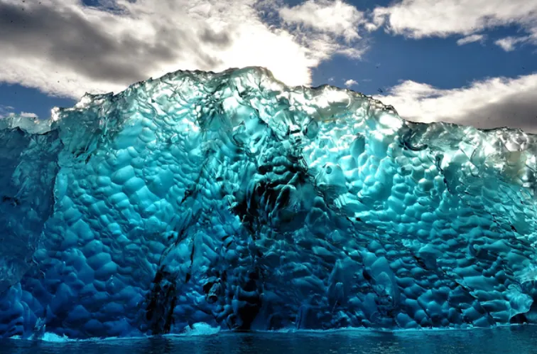 Colores y texturas azules del hielo glaciar sobre el agua