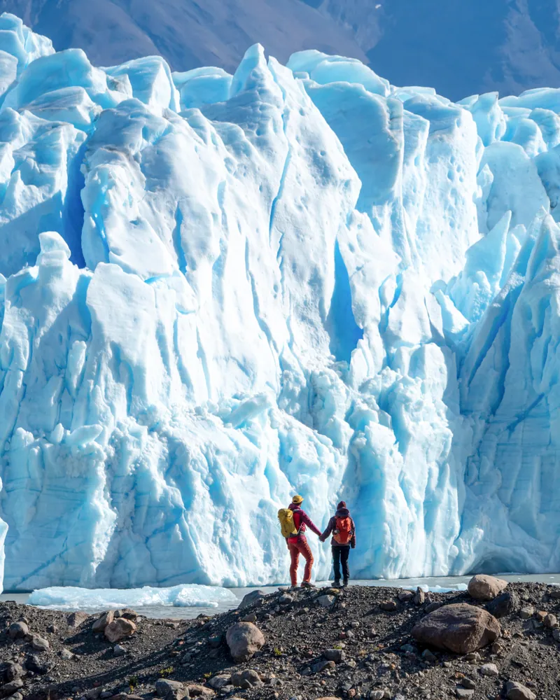 Caminantes junto a la pared de hielo del glaciar Perito Moreno