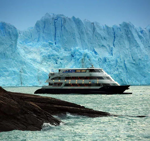 Embarcación navegando frente a un glaciar